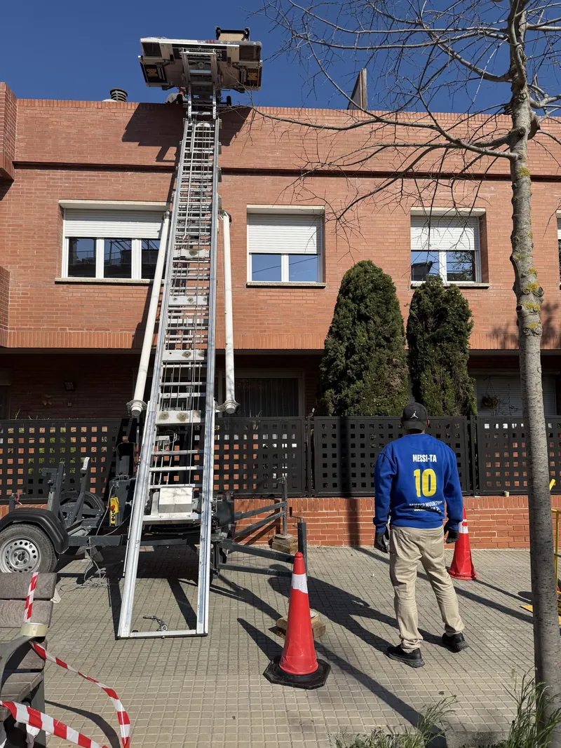 Operario manejando los mandos del elevador montamuebles desde la calle